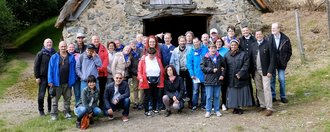 Gruppenfoto vor altem Steinhaus mit Reetdach